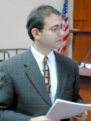 Rabbi holding papers talking after class