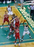 Playing basketball with some players in the air near the basket