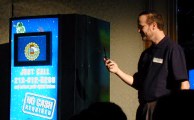 Man holding cell phone next to vending machine