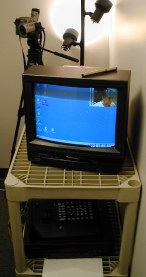 Shelves with TV on top, camcorder on tripod behind it