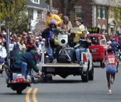 Cameraman on motorcycle, truck with more cameras, and woman running up hill