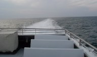 Looking out back of boat to water and wake