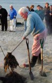 Kevin in blue sweater removing seaweed with pitchfork