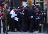 Police standing in a group filling out forms