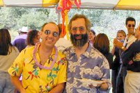 Don and Dan smiling in flowered shirts under a tent