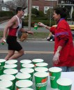 Cups in foreground with one woman in red and one runner