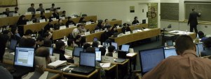 Theater-style classroom, showing many opened laptops