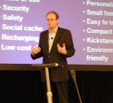 Gary standing on a Segway in front of a slide gesturing with both hands