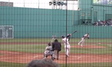 Back of umpire, catcher, swinging batter, front of pitcher, most of infield visible