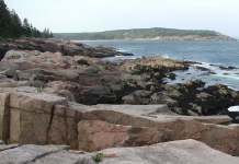 Rocks down to ocean with land in background