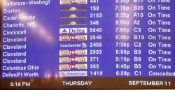 Airport monitor showing Boston, Cedar Rapids, Charlotte, etc., flights On Time and 6:16 PM SEPTEMBER 11