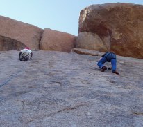 Two guys scurrying up high above