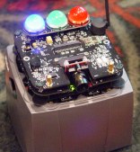 Circuit board with three bright lights on top of gray  cube