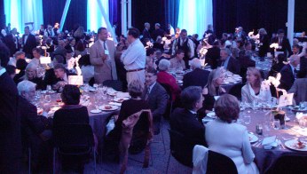 Tables bathed in blue light with people sitting and standing