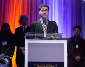 One person at the lectern with three behind