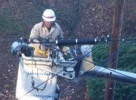 Guy in cherry picker working on a cable bundle