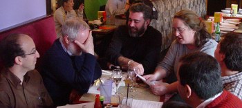 Barb sitting at the end of the table with others and reading from some printouts