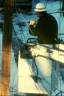 Lineman drilling into a telephone pole from a cherry picker