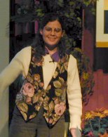 Deena Larson by the plants on the right of the stage